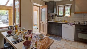 A kitchen with wooden cabinets, a tiled backsplash, and a window overlooking a garden.