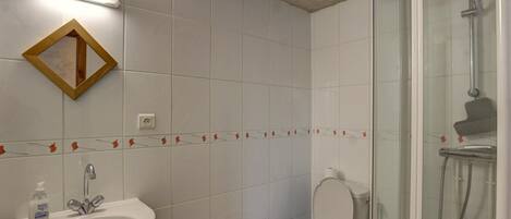 Ein Badezimmer mit Waschbecken, Toilette und Dusche.