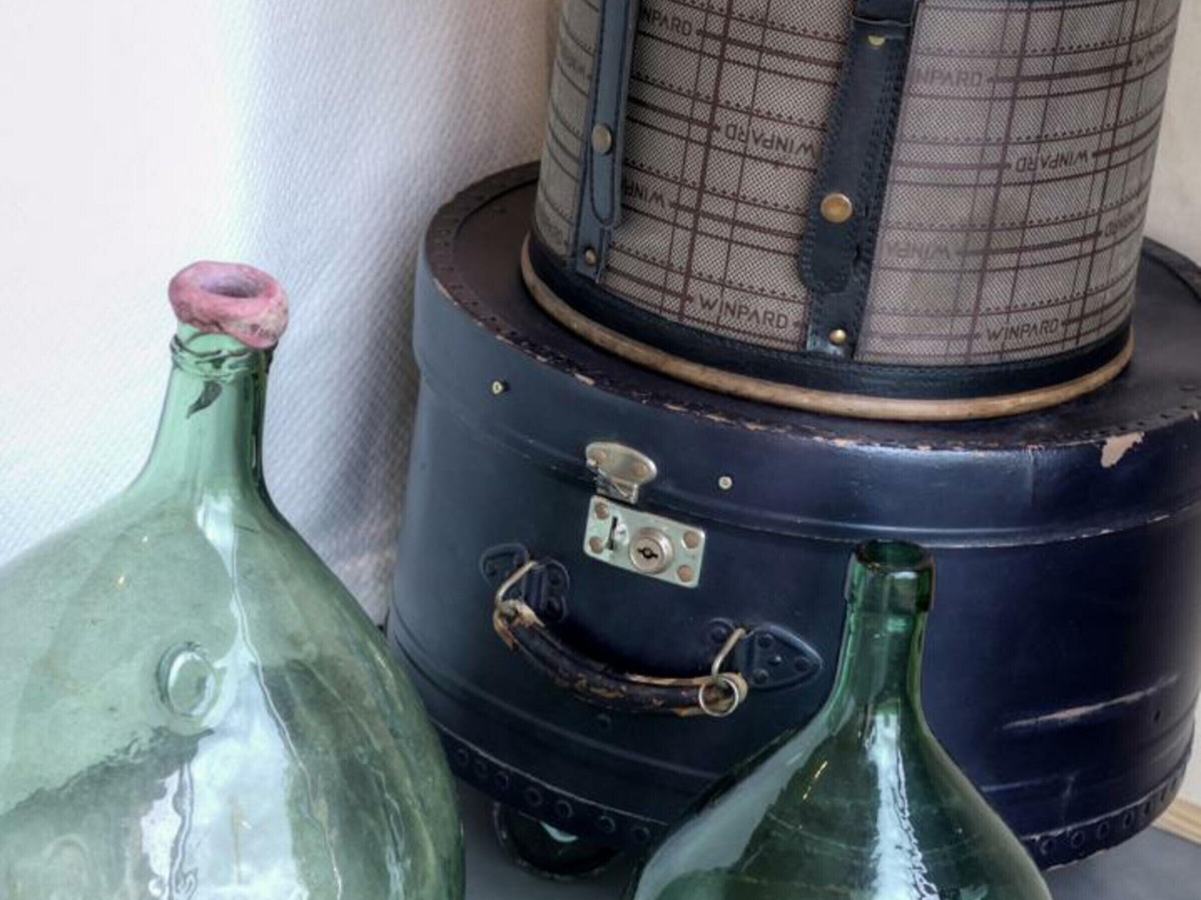 A vintage suitcase with a grid pattern and the brand name 'WINWARD' on it.