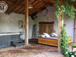 Une chambre rustique avec un lit en bois, un petit bureau et une échelle.