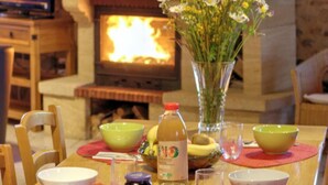 Un tavolo da pranzo con un vaso di fiori, ciotole e una bottiglia di succo.