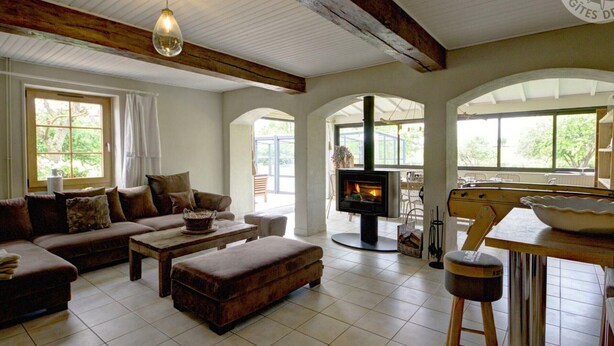 A spacious living room with a fireplace, a sofa set, and a dining area. - Large house with heated private pool and pets allowed (Vivans)