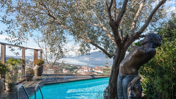 En swimmingpool med utsikt över en stad och berg i bakgrunden.