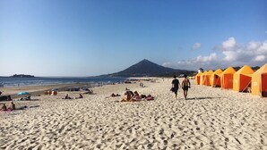En strand med tält och människor.