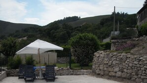 A swimming pool with a stone wall and a white umbrella. - Comfortable house with swimming pool in the ardèchoise mountain (Saint-Joseph-des-Bancs)