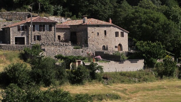 A stone building with multiple windows and a tiled roof, surrounded by trees and a grassy area. - Comfortable house with swimming pool in the ardèchoise mountain (Saint-Joseph-des-Bancs)