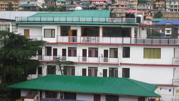 Un immeuble à plusieurs étages doté de balcons, d’un toit végétalisé et d’une façade blanche.