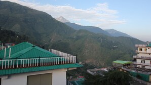 A mountainous landscape with buildings featuring green roofs and balconies. - Hotel Mount View (Dharamshala)