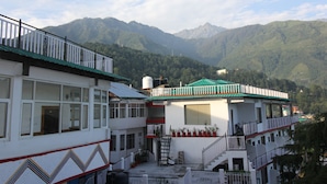 A building with multiple floors, balconies, and a staircase leading to the upper levels. - Hotel Mount View (Dharamshala)