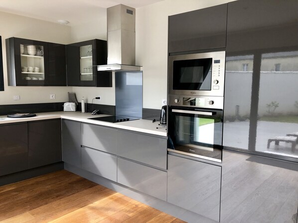 Una cocina moderna con electrodomésticos de acero inoxidable, horno empotrado y microondas.