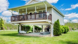 A two-story house with a covered porch, a staircase leading to the upper level, and a small garden area.