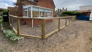 A house with a fenced garden area and a brick chimney. - 1 Orchard Cottages -  a cottage that sleeps 5 guests  in 2 bedrooms (Cromer)