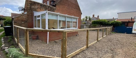 A house with a fenced garden area and a brick chimney.