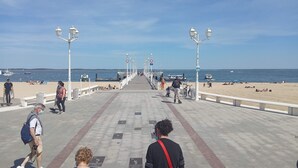 Eine Promenade mit Strand, Bänken und blauem Himmel.