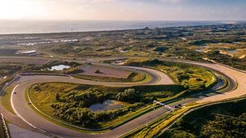 An aerial view of a winding road with a coastal landscape in the background.