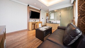 A modern living room with a sofa, a coffee table, a TV, and a kitchen area with a sink and cabinets. - Incheon Prince Tourist Hotel (Incheon)