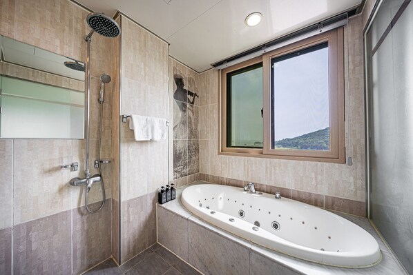 A modern bathroom with a large bathtub, a shower area, and a window with a view. - Incheon Prince Tourist Hotel (Incheon)