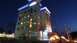 A multi-story hotel with a modern design, featuring a prominent tower with circular windows and a neon sign. - Incheon Prince Tourist Hotel (Incheon)