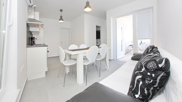 Un espace de vie compact comprenant un coin cuisine, un coin repas et un canapé.