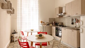 A compact kitchen with a dining area, featuring a stove, microwave, and cabinets. - Bilocale_ Historical Markets (Palermo, Sicilia)
