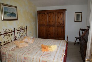 Une chambre à coucher avec un lit, une armoire en bois et une chaise.