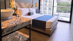 A modern hotel room with a large bed, a marble-topped table, and a view of the city through large windows. - Hotel Lleras Park Concept (Medellín)