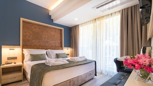 Une chambre d’hôtel avec un grand lit, des tables de chevet, un bureau et une chaise.