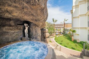 Una piscina al aire libre, sombrillas, tumbonas