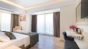 Une chambre d’hôtel moderne équipée d’un lit, d’une table de chevet et d’un petit bureau avec une chaise.