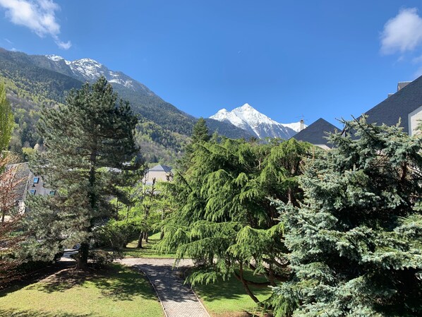 A pathway leading to a house with a mountain view.