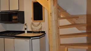 A kitchen with white cabinets, a built-in stove, and a wooden staircase. - Gerbers 1870 Chalet - A touch of Bavaria in Canada (Killaloe)
