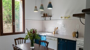 A kitchen with a dining table, chairs, a dishwasher, and a stove. - Family house l'Ospedale - Porto-Vecchio (Porto-Vecchio)