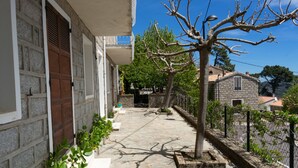 A stone-paved pathway leading to a building with a wooden door and a tree in the center. - Family house l'Ospedale - Porto-Vecchio (Porto-Vecchio)