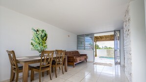A dining area with a wooden table and chairs, a sofa, and a painting on the wall. - Private pool, Oceanview, Centrally located! (Puerto)