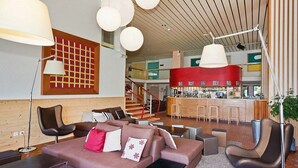 Een moderne zithoek met een bank, stoelen en een bar.