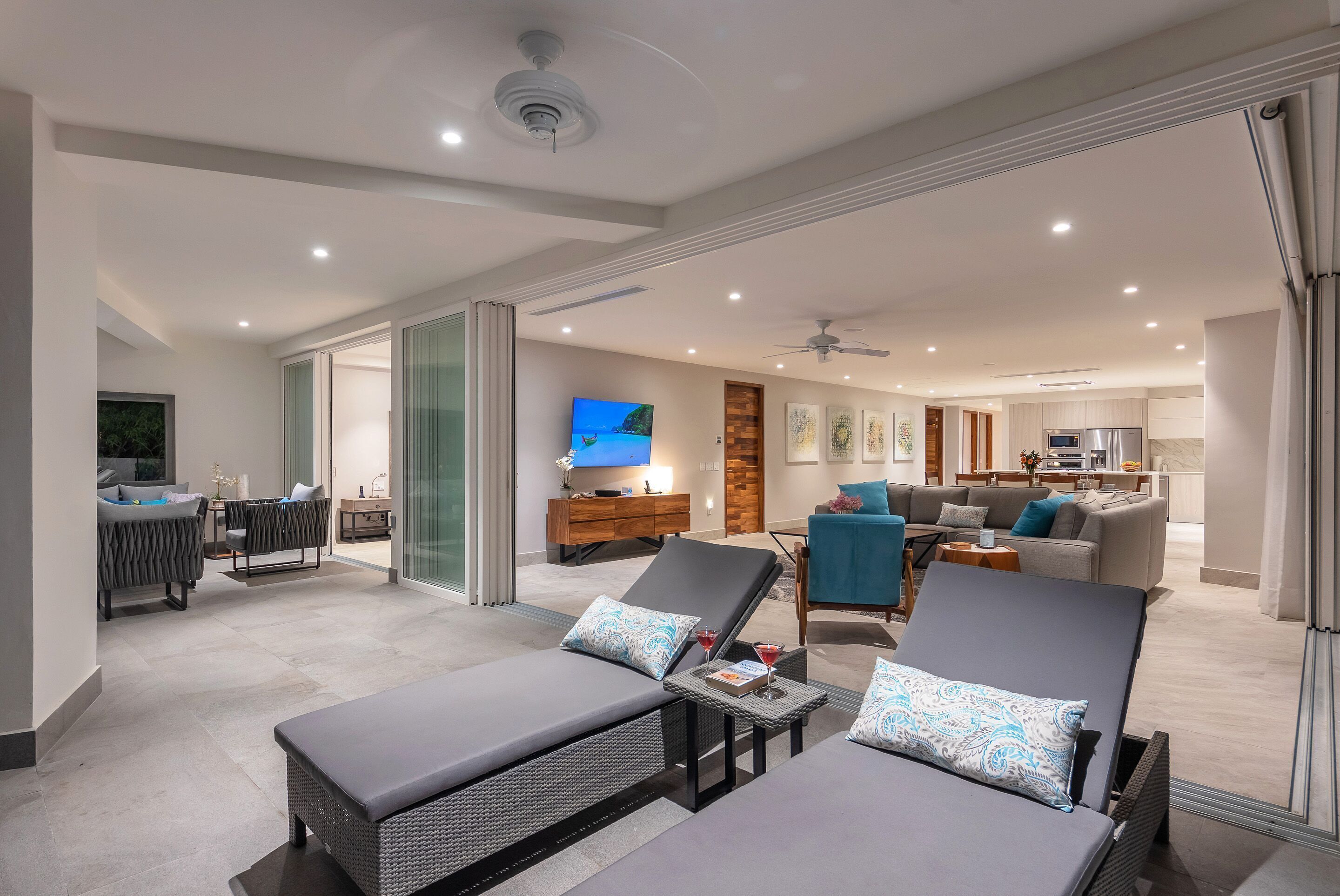 A modern living room with a sofa, a dining area, and a kitchen.