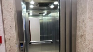 Un ascensor con paredes metálicas y una pantalla digital que muestra el número 2.