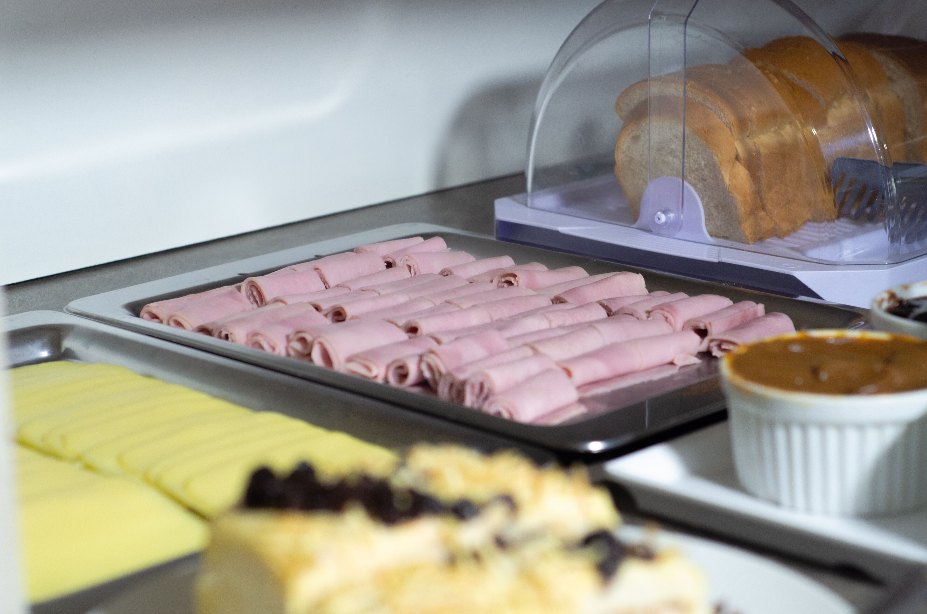 Un bufé con diversos alimentos, incluyendo carnes frías, pasteles y una cazuela de sopa.