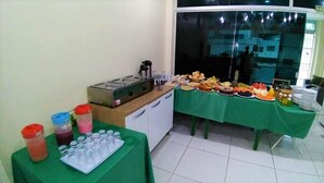 A buffet setup with various food items and a beverage station. - Pousada Catamarã Praia de Pajuçara (Maceió)