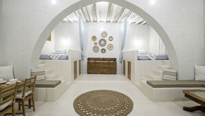 Une chambre moderne avec un lit placé au centre, un coin repas comprenant une table et des chaises, et un tapis décoratif.