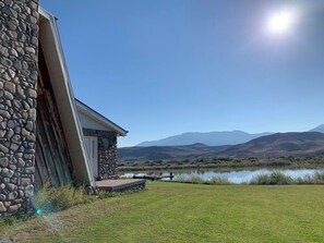 A stone building with a deck overlooking a lake and mountains. - 10 Bedrooms, 12 Bathrooms, 1985 Rustic Lodge located in the Sevier Valley. (Sevier)