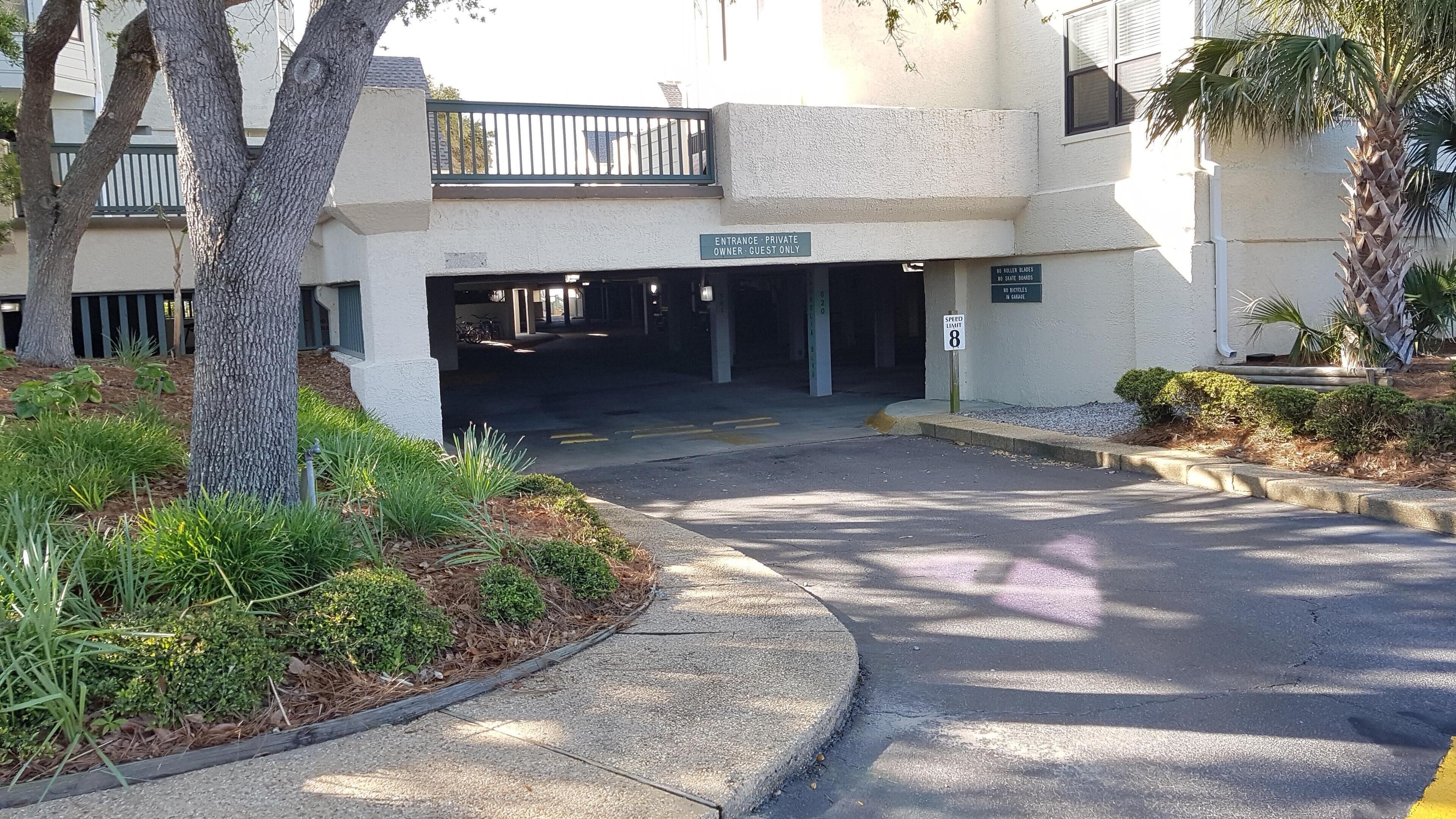 Una entrada privada con una señal de límite de velocidad de 8, y un letrero que indica prohibido el uso de patines, patinetas y bicicletas en el garaje.
