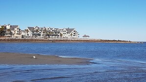 A beachfront property with multiple-story buildings, a sandy beach, and a calm sea. - Relaxing beachfront condo (Fripp Island)