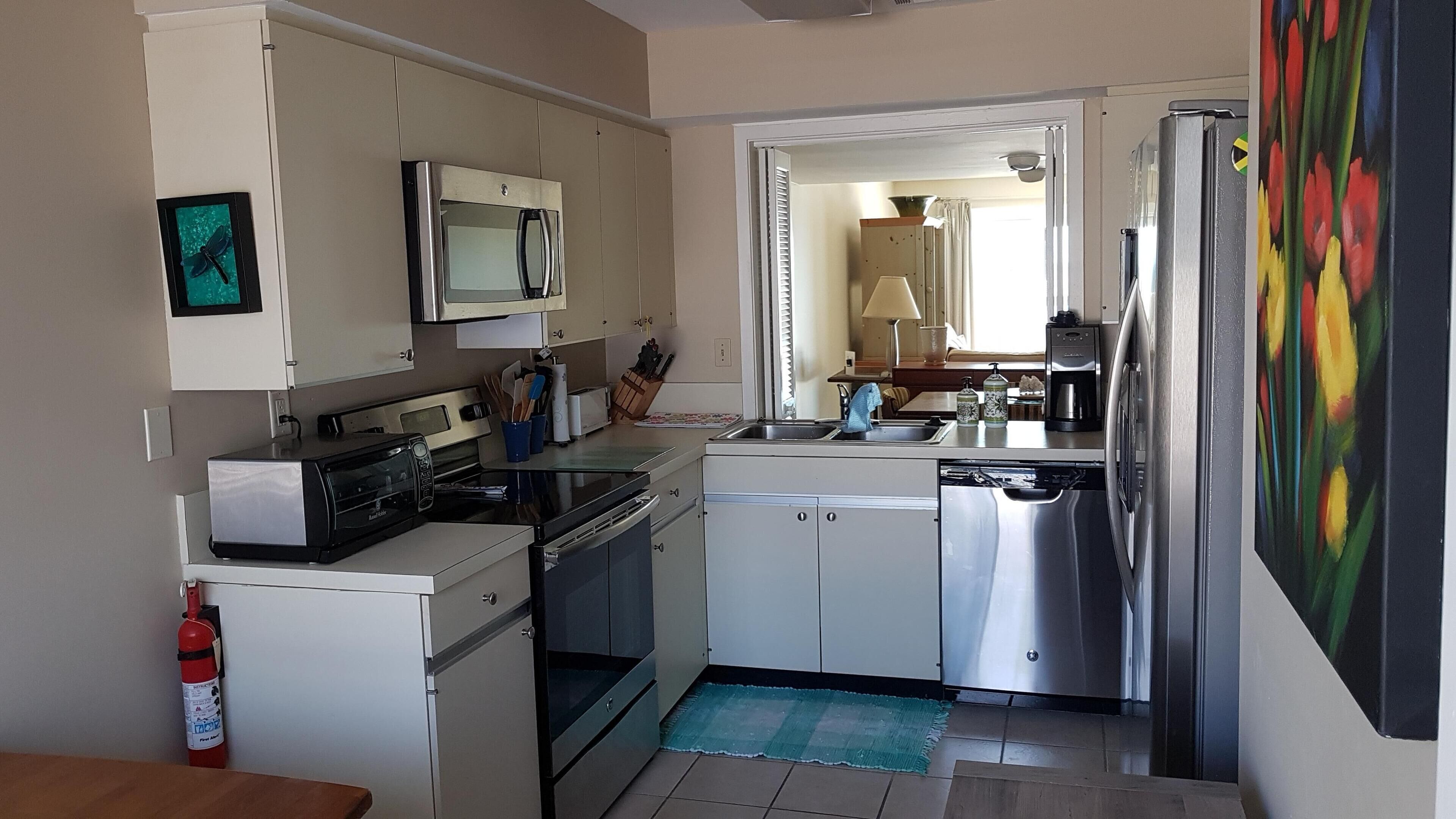 A compact kitchen with a microwave, toaster, and stainless steel appliances.