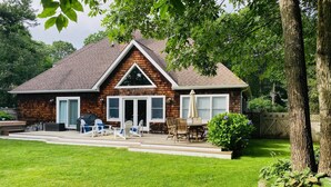 A two-story house with a covered patio, a grill, and a well-maintained lawn. - Light and Bright East Hampton Home, Perfect Location! (East Hampton)
