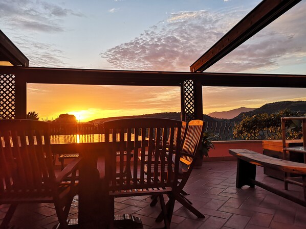 Relax in a serene outdoor seating area with a breathtaking view of the surrounding mountains and water.