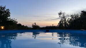 A tranquil outdoor swimming pool at dusk with a clear view of the sky and surrounding trees. - Farmhouse Podere dell'Olmo in Umbria - Holiday Home (Ida's House) (Amelia)