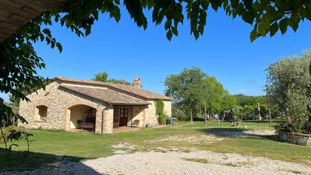 A stone building with a tiled roof, a covered patio, and a gravel driveway. - Farmhouse Podere dell'Olmo in Umbria - Holiday Home (Ida's House) (Amelia)