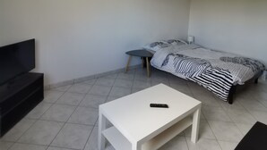 Una stanza piccola e arredata in modo essenziale, con un letto, una TV e un tavolo.