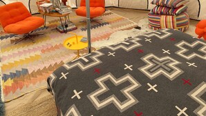 A tent interior with orange chairs, a small table with books and a lamp, and a patterned rug. - Luxury Glamping!  Near Horseshoe, Antelope Canyon, Lake Powell, Grand Canyon.' (Page)